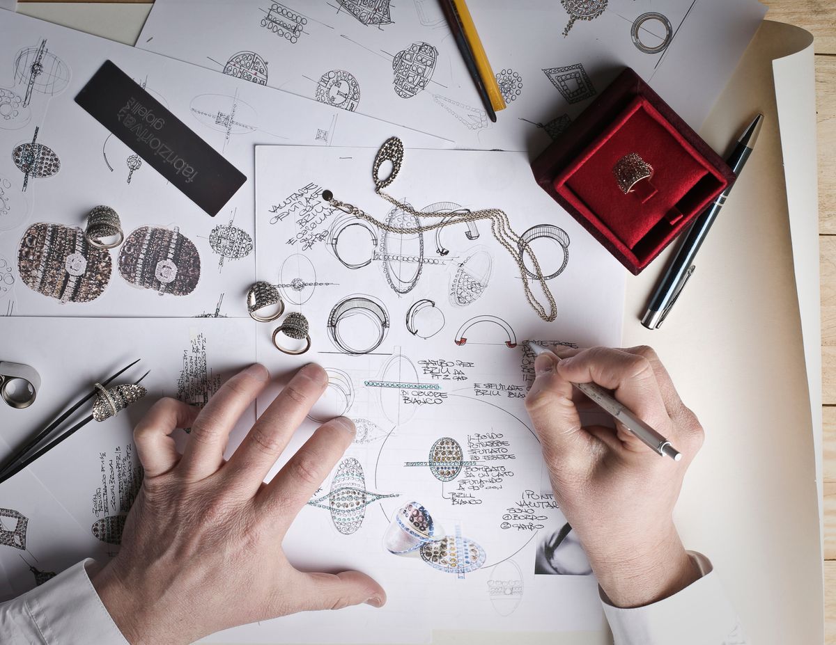 Hands carefully tracing the inside of a ring on white paper with a pencil next to a ruler.