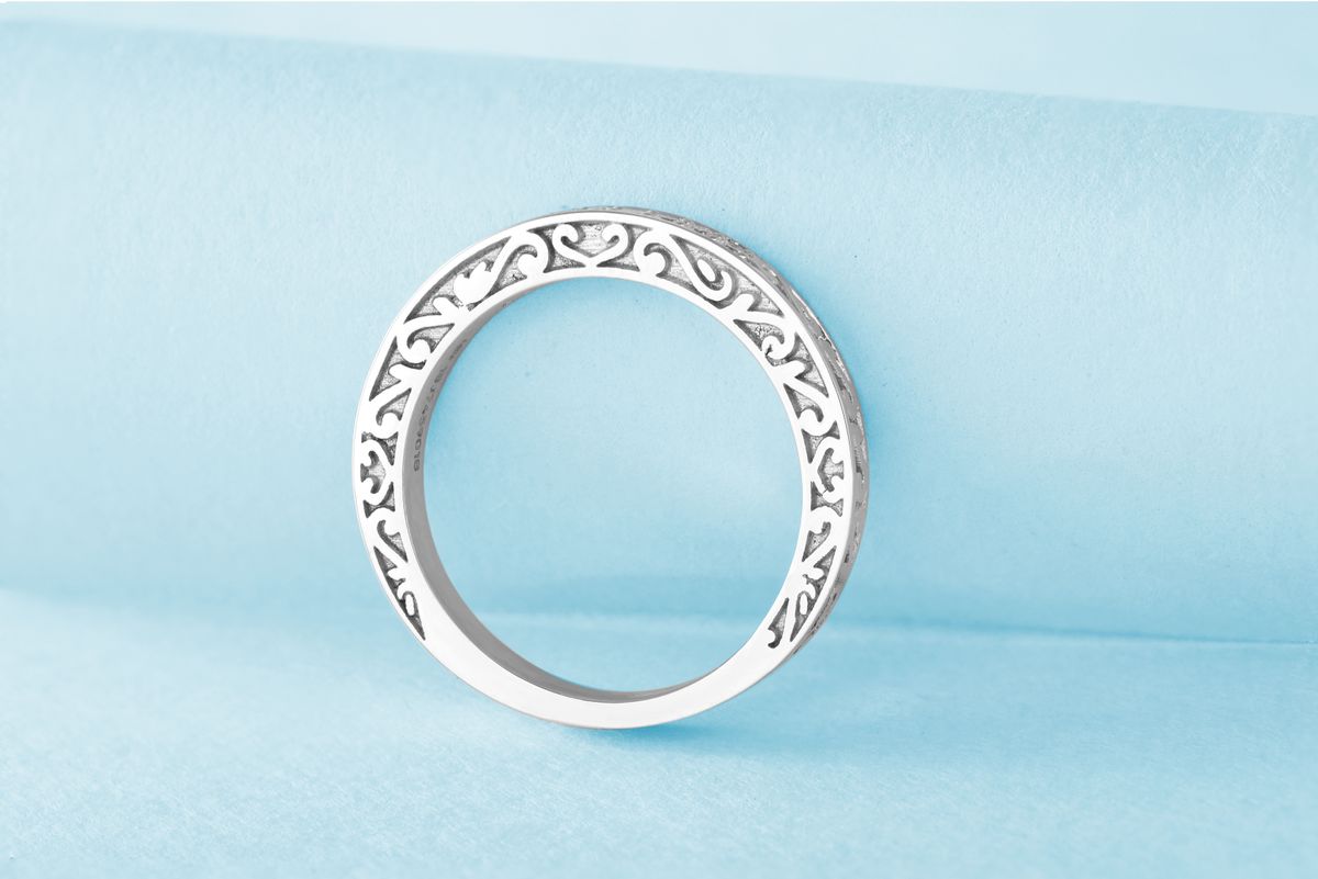 A macro close-up of the tiny "S925" hallmark stamp engraved on the inner band of a ring.