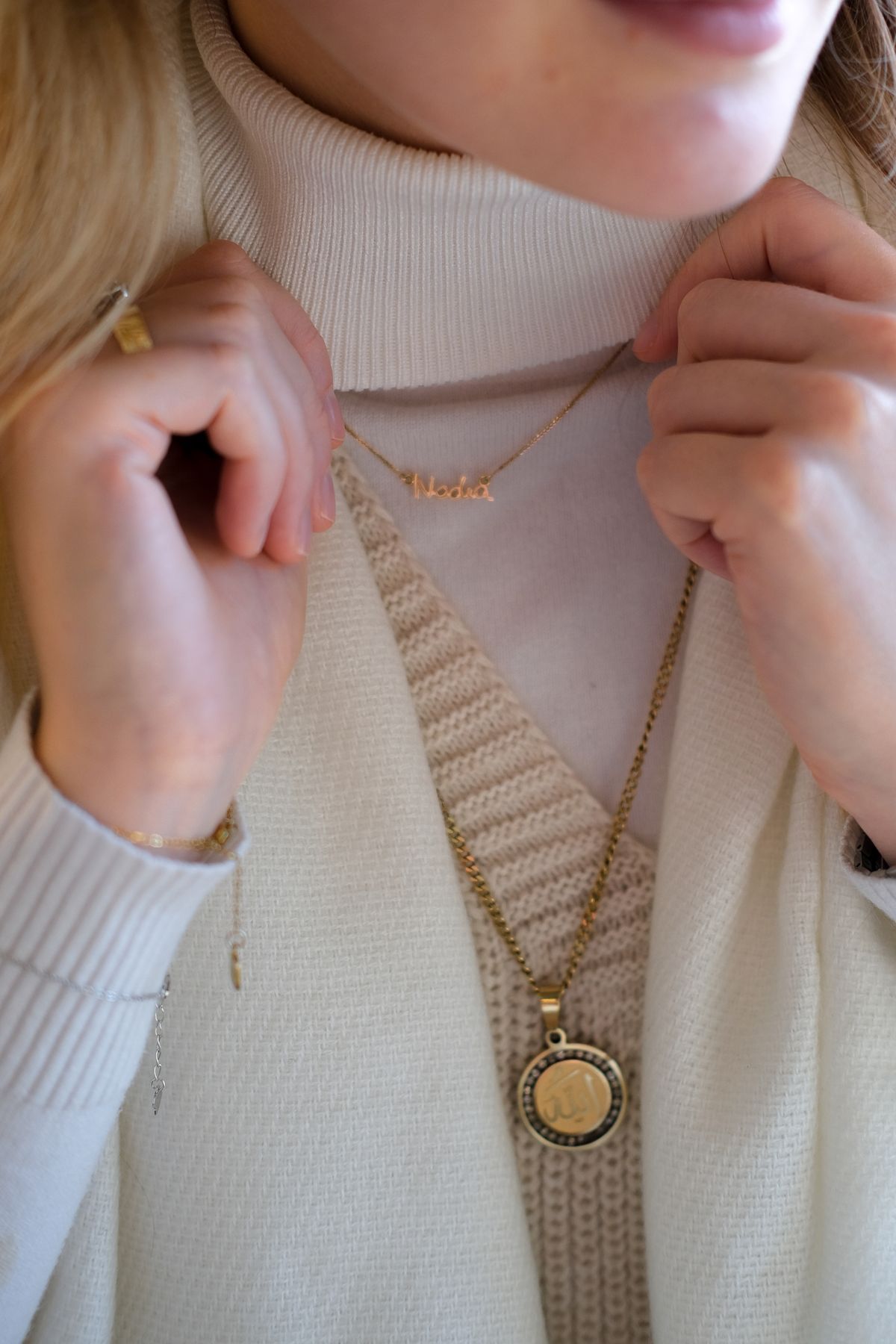 A simple plain black turtleneck elevated with a bold chunky gold chain necklace and matching rings.