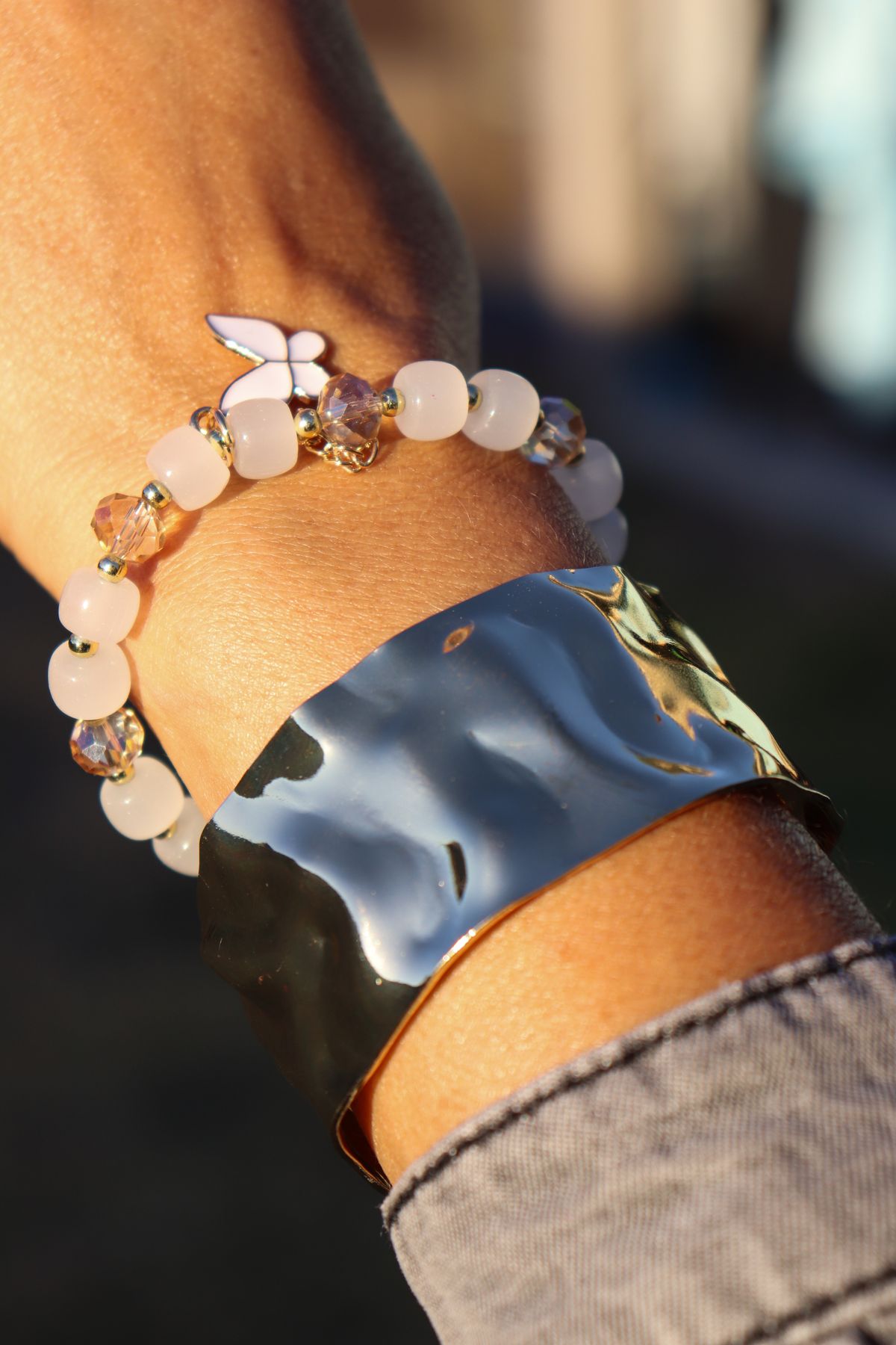 An oversized blazer sleeve pulled up to reveal a stack of gold bangles.