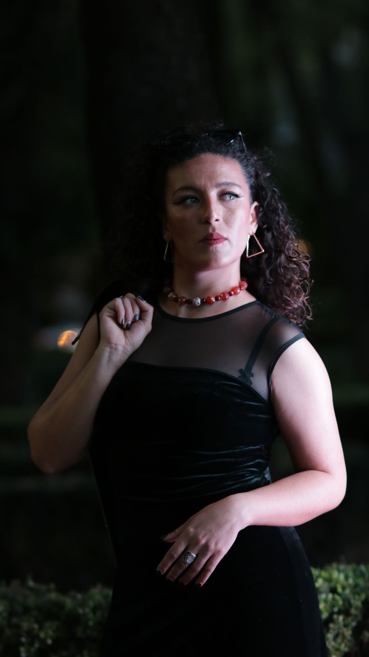 An elegant evening gala setup with a woman in a sleek cocktail dress wearing eye-catching drop earrings.