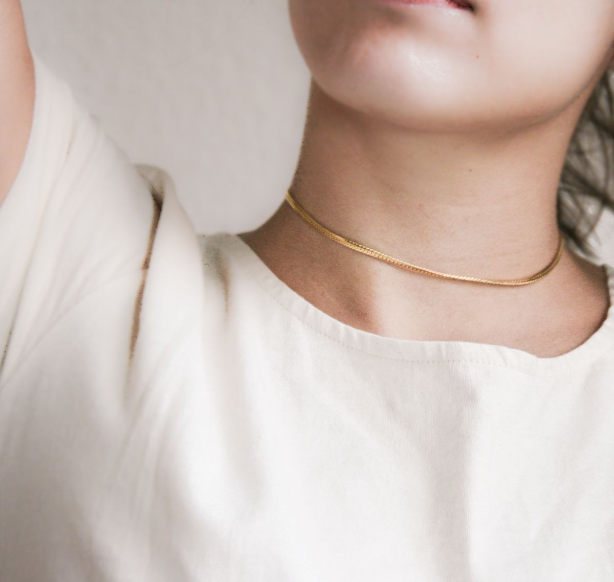 A slim gold choker resting delicately on the collarbone — the modern revival of a retro classic.