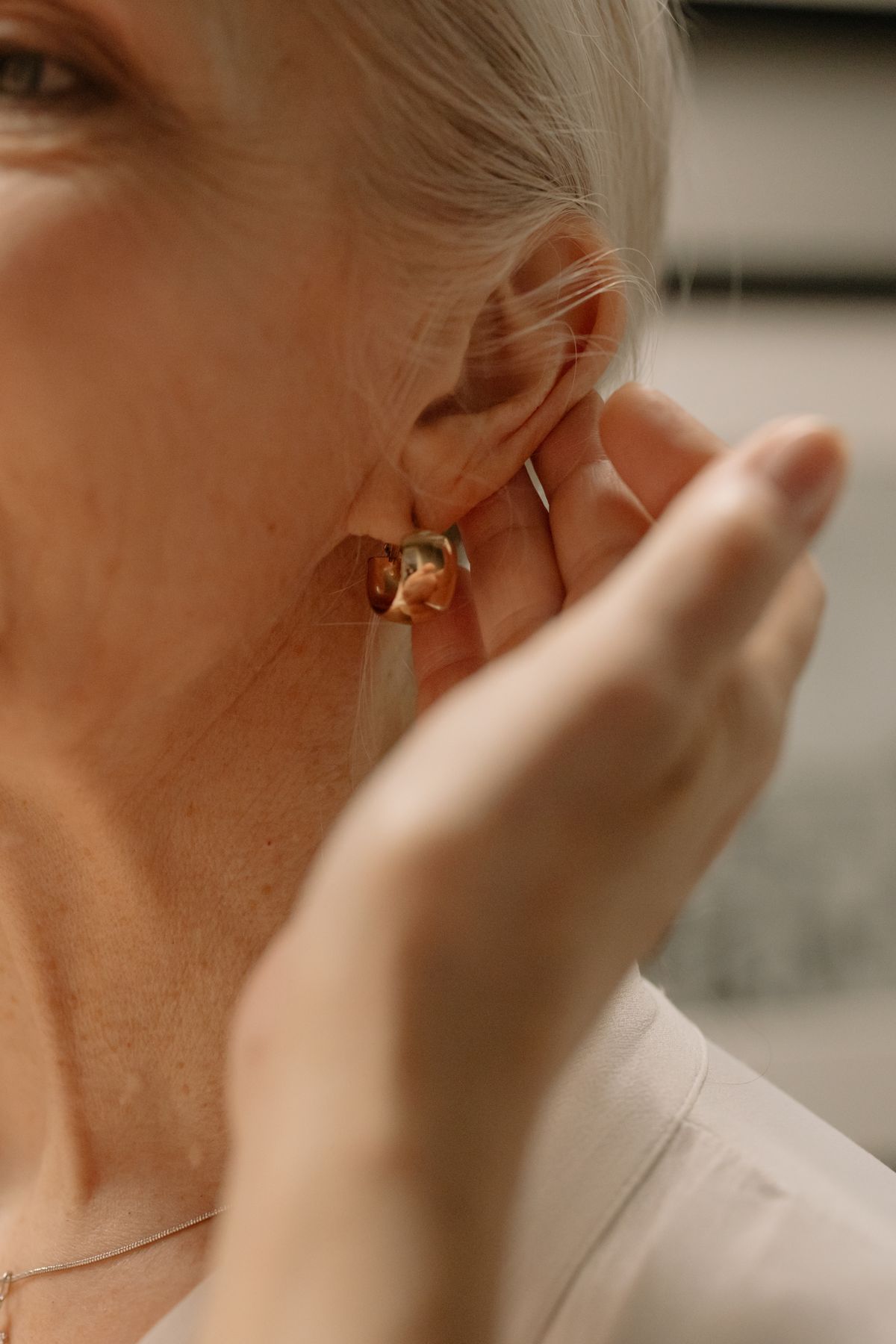 A gold huggie hoop hugging the earlobe — the foundation of any curated ear.