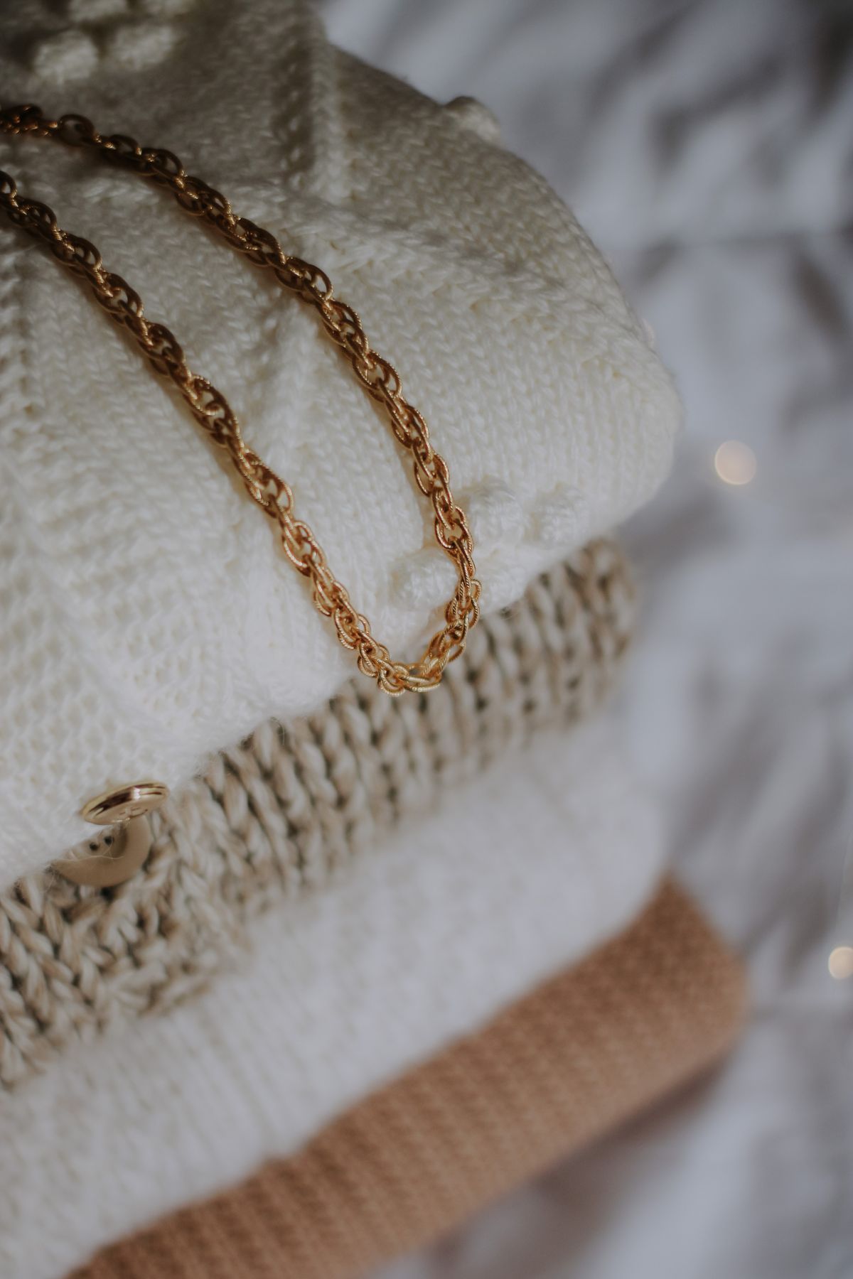 Drape a bold gold chain directly over a monochrome turtleneck to create a striking focal point.