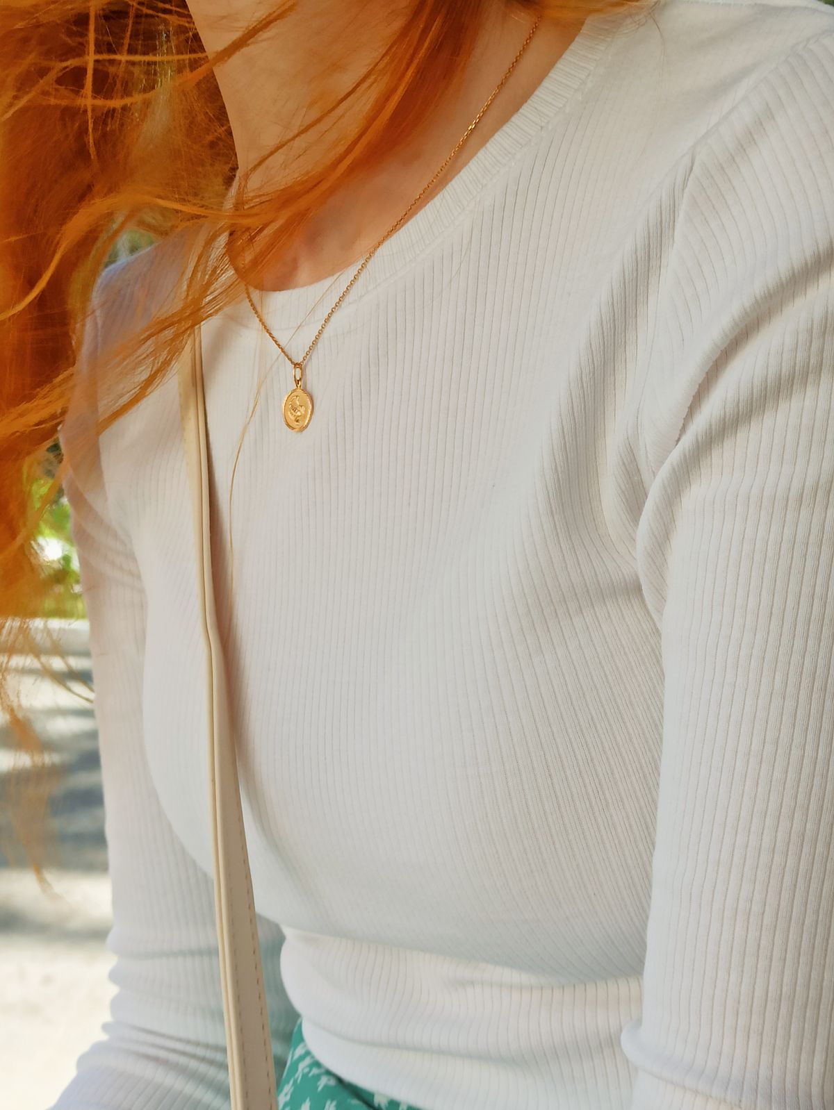 Waterproof pendants peek through an open linen shirt for effortless resort style.